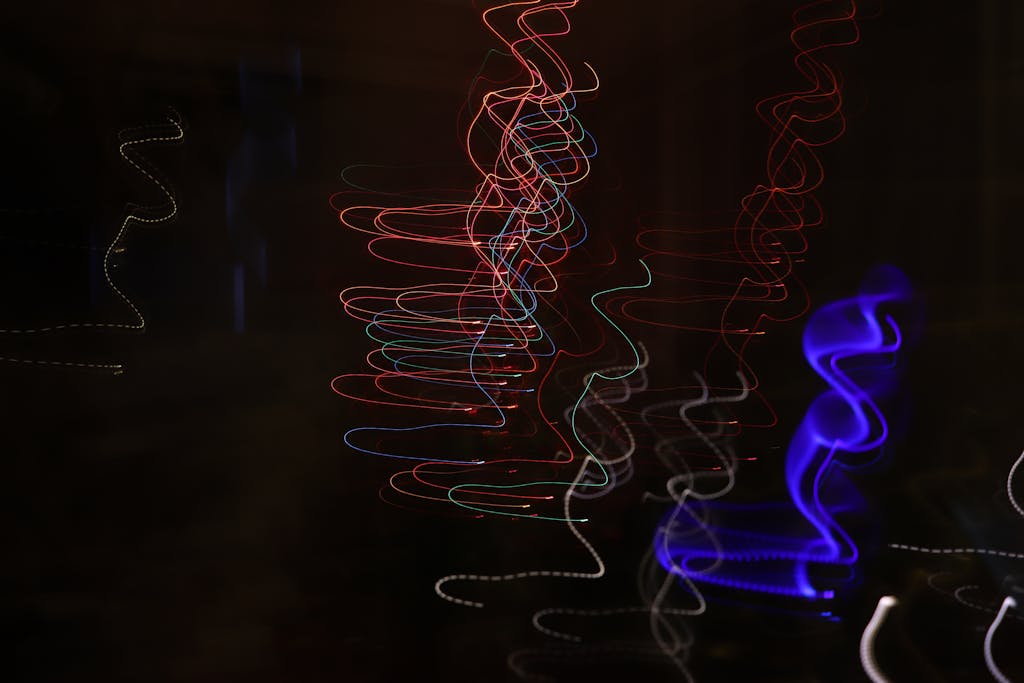 Vibrant abstract light trails create an artistic display on a dark background.